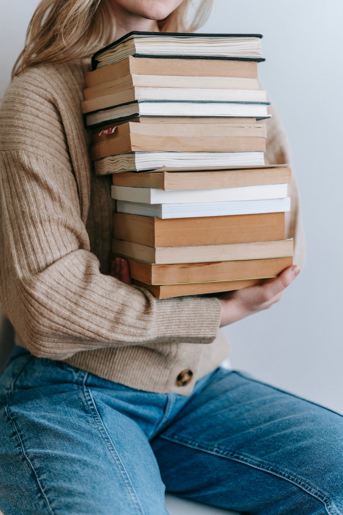 Person Carrying a Stack of Books